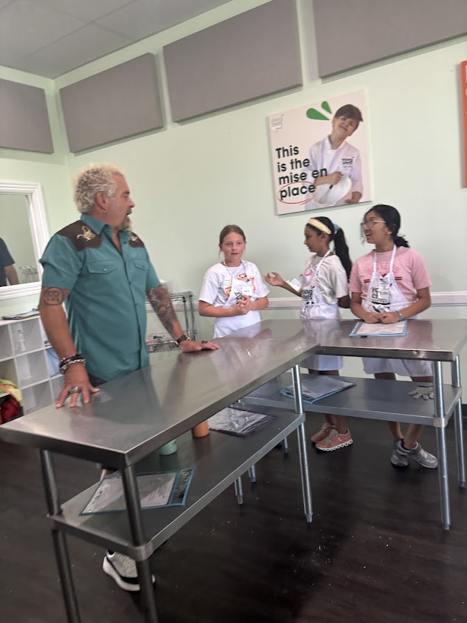 Guy Fieri talks with Young Chefs Academy Rogers campers during a surprise visit to the academy.